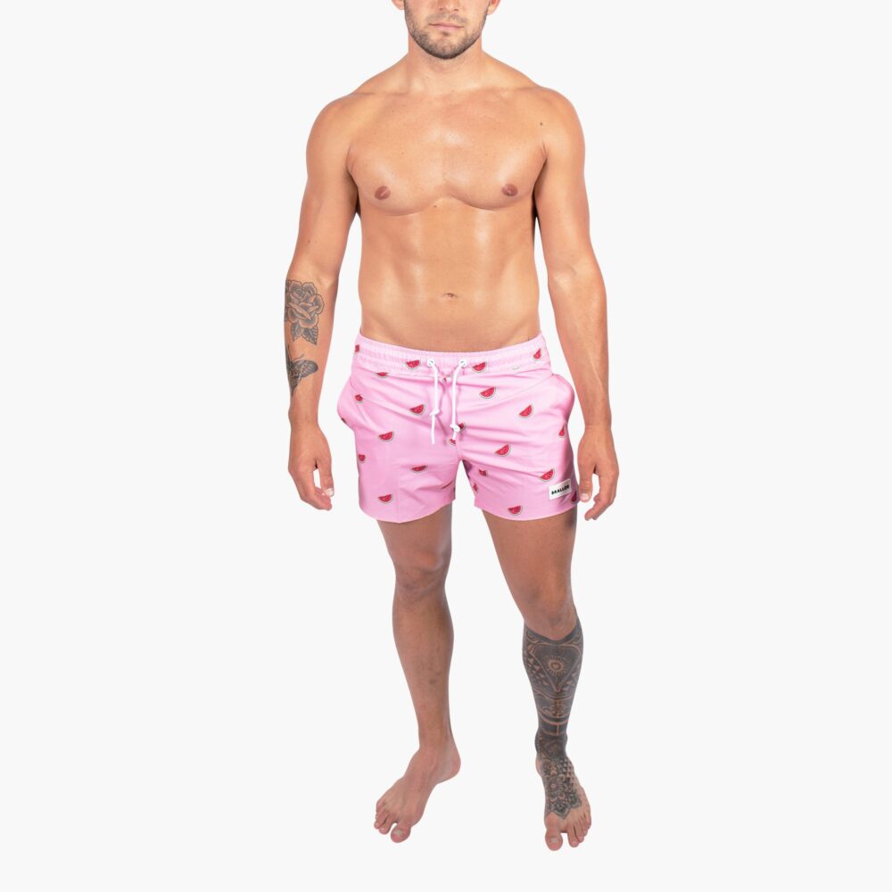 en kille med rosa badbyxor med vattenmeloner på från brallor